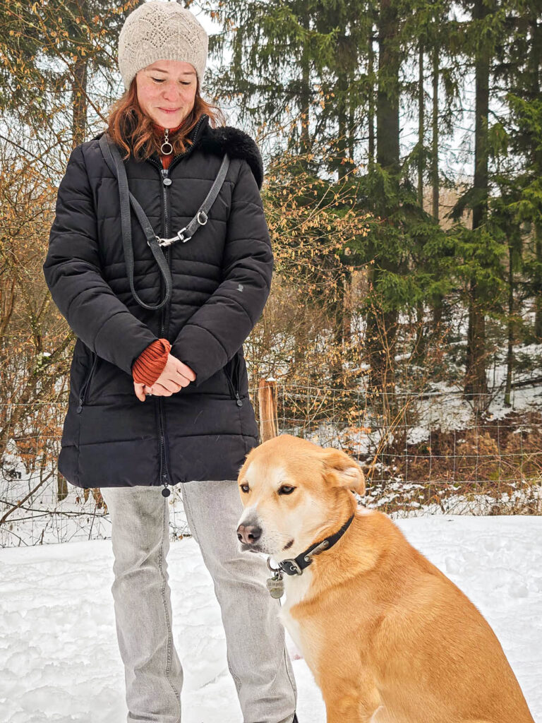 Schulhund im Training mit Halterin im Schnee