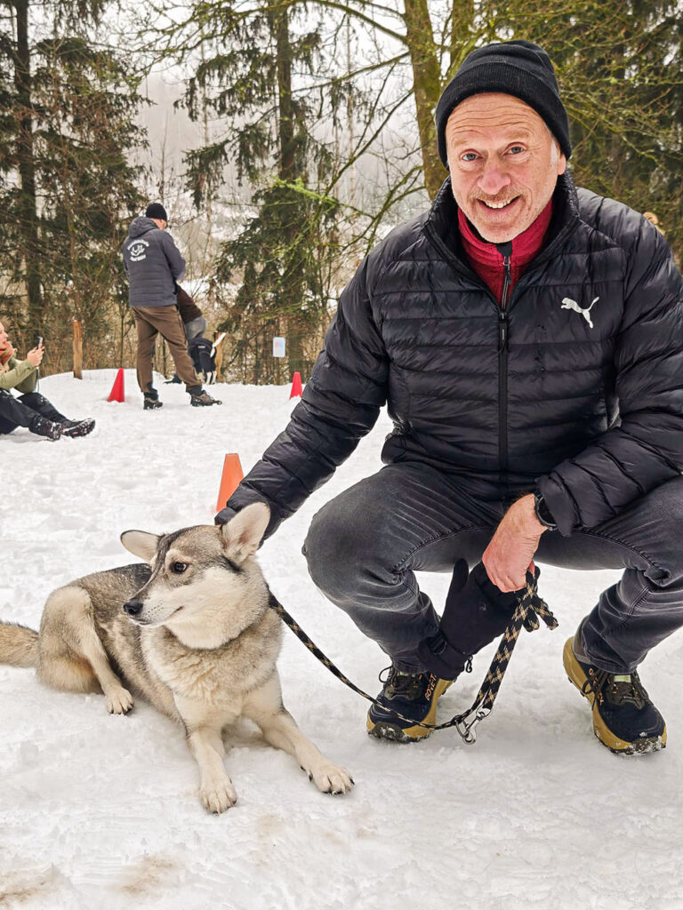 Schulhund im Training mit Halter im Schnee